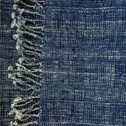 Handspun cotton in natural indigo tones, hand-woven in Northeastern Thailand by women-led weaving groups in the Khon Kaen region. Plant-dyed with fermented indigo leaves. 40 × 200 cm.