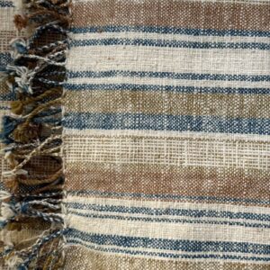 Handspun cotton in natural stripe pattern — indigo, copper and cream tones, hand-woven in Northeastern Thailand by women-led weaving groups in the Khon Kaen region. Plant-dyed. 80 × 200 cm.