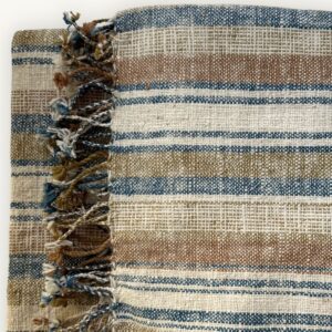 Handspun cotton in natural stripe pattern — indigo, copper and cream tones, hand-woven in Northeastern Thailand by women-led weaving groups in the Khon Kaen region. Plant-dyed. 80 × 200 cm.