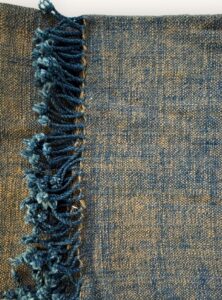 Handspun cotton in warm ochre and deep indigo, hand-woven in Northeastern Thailand by women-led weaving groups in Thailand. Plant-dyed. 80 × 200 cm.
