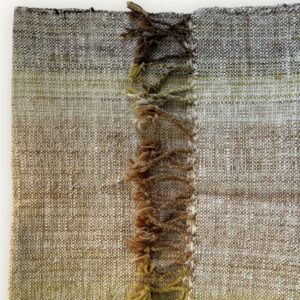 Handspun cotton in olive and earth tones, hand-woven in Northeastern Thailand by women-led weaving groups. Plant-dyed. 40 × 200 cm.