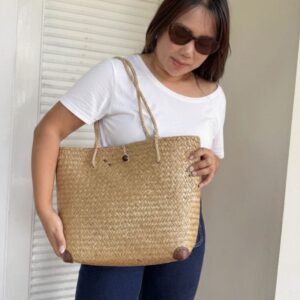 Handwoven Krajood seagrass bag from Koh Samui — crafted by a mother-daughter duo using a traditional technique passed down for generations. Every bag unique.