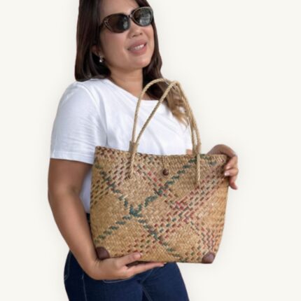 Handwoven Krajood seagrass tote bag in natural tones, made by a mother-daughter duo in Koh Samui, Southern Thailand. Traditional weaving technique. Size S.