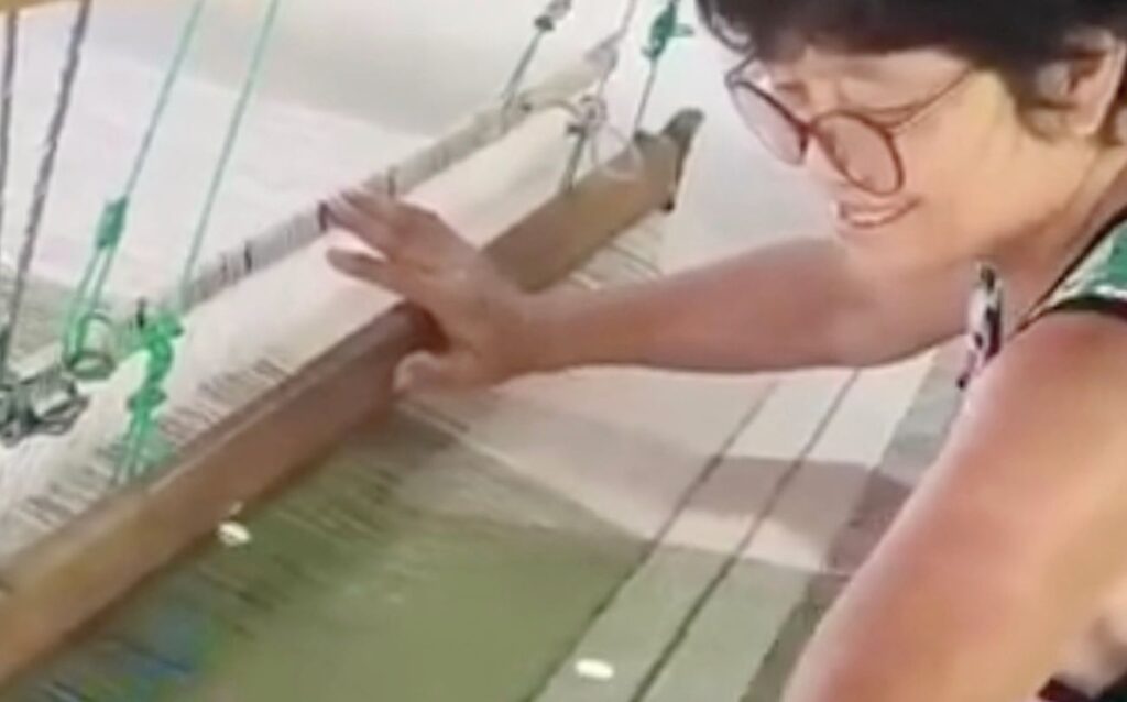 Woman weaving on a traditional wooden loom, handwoven Ikat textile production, Thailand