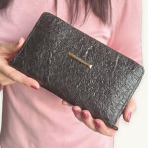 Hands holding black Ambani Fish Leather Wallet - presented by So Rare Pieces