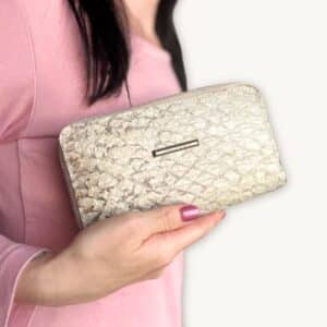 Hand holding a white fish leather wallet branded with little golden tag Ambani - presented by SoRarePieces